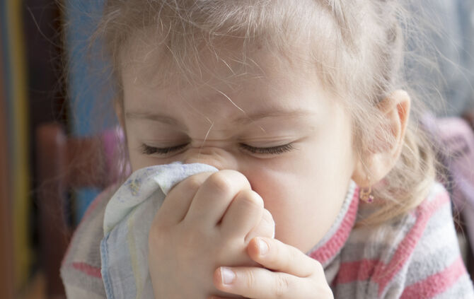 Sick girl sneezing In handkerchief