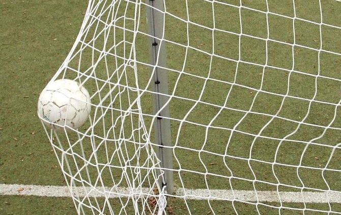 Fusbbal im Tornetz. Keiner spielt, aber das Tor hat eine Beule